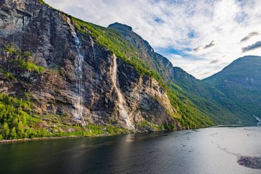 Güneş doğarken Norveç 'teki Geiranger fiyordundan geçerken yolcu gemisinden gelen izlenim