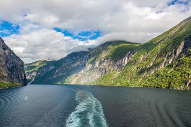 Güneş doğarken Norveç 'teki Geiranger fiyordundan geçerken yolcu gemisinden gelen izlenim