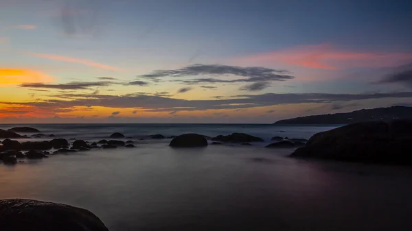 Tayland 'da Kamala plajında renkli günbatımının uzun pozlama resmi