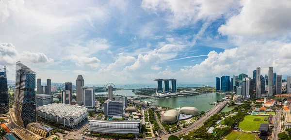 Gündüz vakti Formula 1 yarışına hazırlanırken Singapur siluetinin ve körfez kenarındaki bahçelerin hava panoramik resmi.