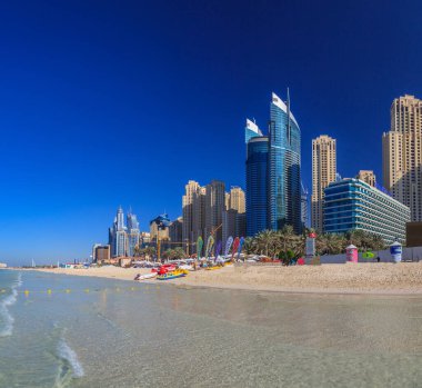Dubai 'nin Marina bölgesini akşam saatlerinde plajdan izleyin.