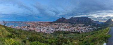 Cape Town ile Tablo Dağı 'nın hava kararırken çekilmiş panoramik fotoğrafı. Aydınlanmış şehir Eylül 2013' te Güney Afrika 'da çekildi.