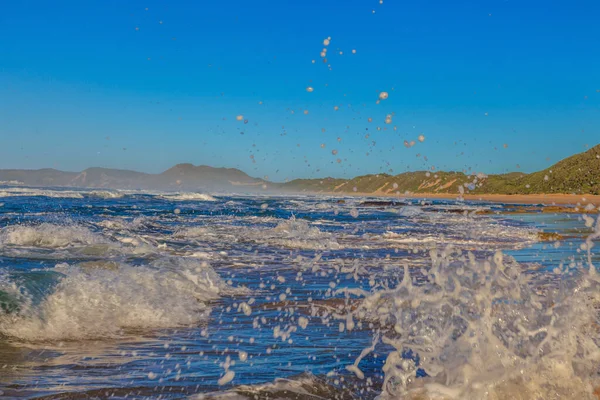 南アフリカのブレントンビーチでの朝の地面近くの位置から撮影された前景に水しぶきと波の破壊の映像 — ストック写真