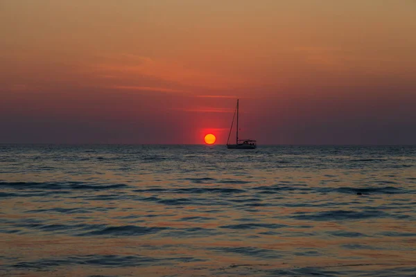 Foto Van Een Zonsondergang Boven Zee Met Een Boot Achtergrondlicht — Stockfoto