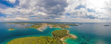 Hırvatistan 'daki Vrsar limanının gündüz vakti turkuaz suyla çekilmiş panoramik hava aracı resmi