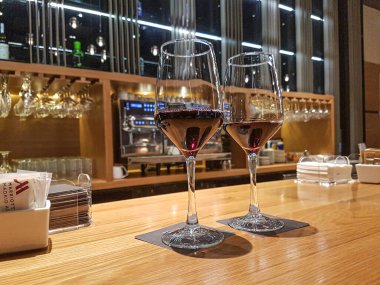 Ahşap tezgahta kırmızı şarapla dolu şarap kadehleri zemin perspektifinden