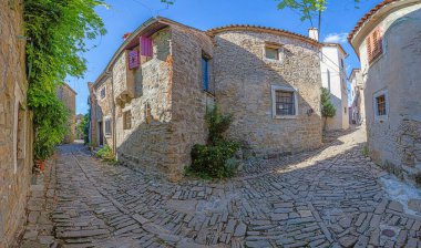 Gündüz vakti Istrian yarımadasındaki ortaçağ Groznjan kasabasının tipik sokak manzarası.