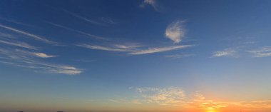 Yazın gün batımında güneşli dramatik ve renkli bir gökyüzü.