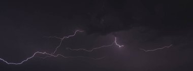 Gece gökyüzünde parlayan bulutların olduğu bir ışık resmi.