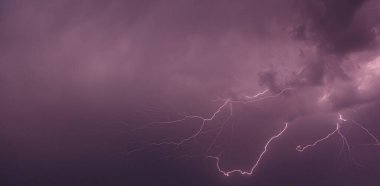 Gece gökyüzünde parlayan bulutların olduğu bir ışık resmi.