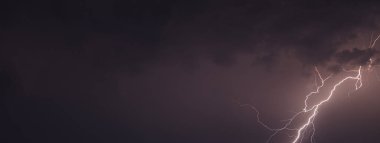 Gece gökyüzünde parlayan bulutların olduğu bir ışık resmi.