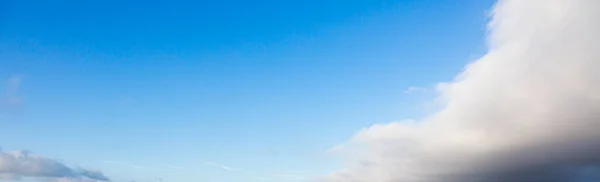 Image of a partly cloudy and partly clear sky during the day without horizon