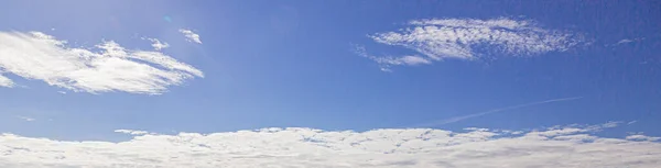 Image of a partly cloudy and partly clear sky during the day without horizon