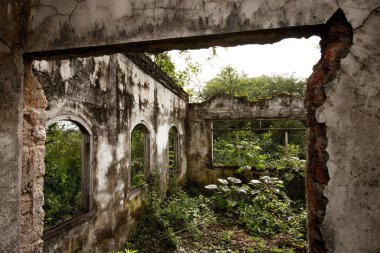 Arkasında köprü olan taş bir bina.