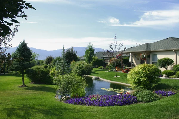 Home with water pond incorporated into landscaping.