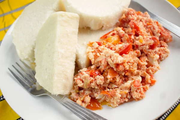 Lezzetli kaynamış tatlı patates ve yanında çatal ve bıçakla renkli sarı masa örtüsüne saçılmış omlet.