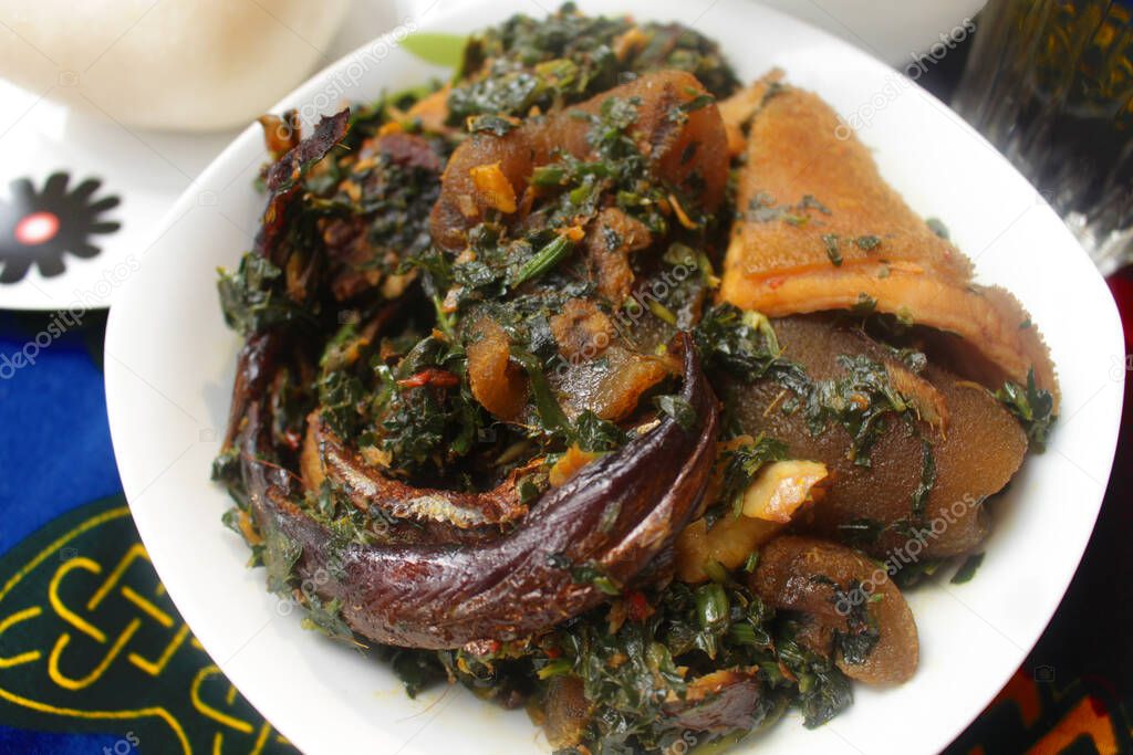 Close up view of a bowl of delicious vegetable soup cooked with round fish, crayfish, beef, kpomo and shaki meat
