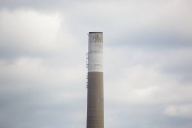 Gökyüzü bulutlu endüstriyel baca görüntüsü.