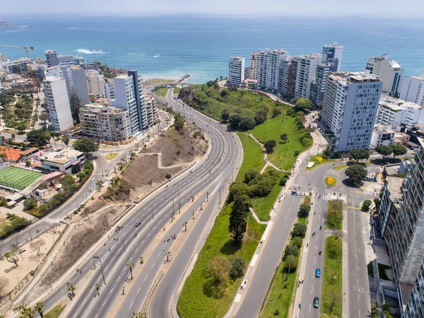 Pazar günleri Lima Peru 'nun insansız hava aracıyla yapılan hava görüntüsü. Sokağa çıkma yasağı nedeniyle özel arabalara izin verilmiyor. İnsanlar plaja doğru bisiklet sürüyorlar. Miraflores Bölgesi.