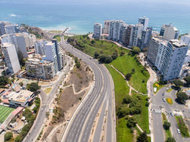 Pazar günleri Lima Peru 'nun insansız hava aracıyla yapılan hava görüntüsü. Sokağa çıkma yasağı nedeniyle özel arabalara izin verilmiyor. İnsanlar plaja doğru bisiklet sürüyorlar. Miraflores Bölgesi.