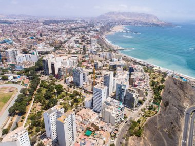 Pazar günleri Lima Peru 'nun insansız hava aracıyla yapılan hava görüntüsü. Sokağa çıkma yasağı nedeniyle özel arabalara izin verilmiyor. İnsanlar plaja doğru bisiklet sürüyorlar. Miraflores Bölgesi.