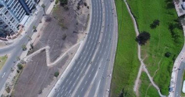 Pazar günleri Lima Peru 'nun insansız hava aracıyla yapılan hava görüntüsü. Sokağa çıkma yasağı nedeniyle özel arabalara izin verilmiyor. İnsanlar plaja doğru bisiklet sürüyorlar. Miraflores Bölgesi.