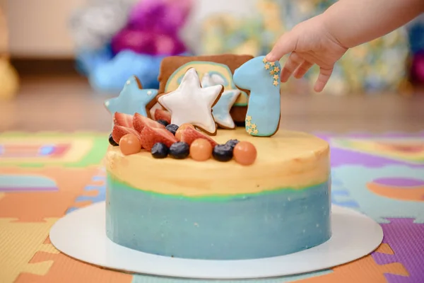 Details of a first year birthday cake in blue, for boy. Colorful decoration of a first year birthday cake