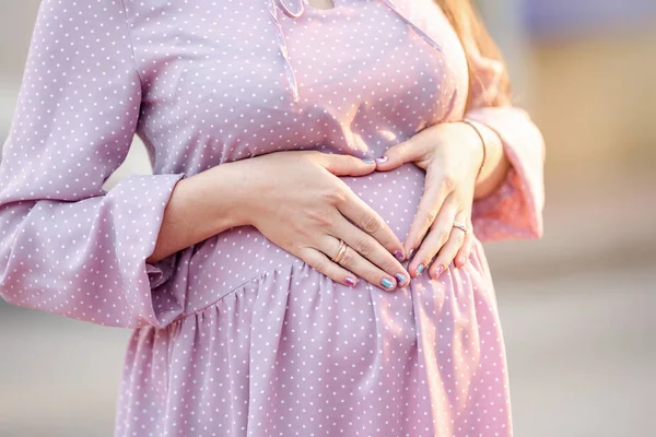 Close-up of big pregnant belly woman in polka dot dress
