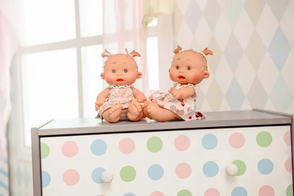 Cute doll sits on the wood background.