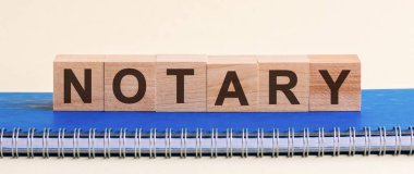 Not: Alfabe blokları tarafından oluşturulmuş. Noter - siyah harfli ahşap bloklardan yapılmış bir kelime, mavi bir notun üzerinde bir sıra blok var..