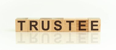 TRUSTEE - word from wooden blocks with letters, promotion code, top view on white background.Mirror image of the inscription on the surface. clipart