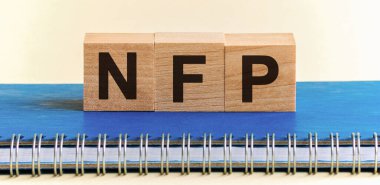 Tahta bloklarda NFP yazıyor. Çiftlik dışı Maaşlar - temel ekonomik gösterge. NFP - siyah harfli ahşap bloklardan oluşan bir kelime, mavi bir Notepad üzerinde bir sıra blok bulunuyor. Beyaz arka plan, ön manzara. Promosyon kodu, tanıtım kodu kavramı..