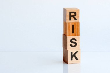 Tahta blokta yazan risk kelimesi. Ahşap masa üzerindeki risk metni, konseptin için. Beyaz masa arkasında RISK küp tahta bloklar. Ev, kriz, ekonomik durgunluk, Buy konsepti. Solda boş alan