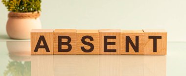 Beyaz üzerine izole edilmiş yapı taşlarıyla yapılmış bir kelime. Arka planda solda saksı çiçeği var..