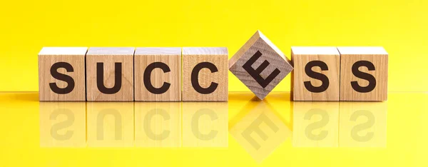 木のブロックに書かれた成功単語 テーブルの上の成功テキスト コンセプト 言葉の成功は テーブルの上に横たわっている木製の建物のブロックと薄い黄色の背景で作られています — ストック写真
