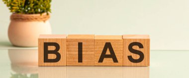 BIAS sözcüğü, arka planda bir çiçekle küp bloklardaki ahşap bir masanın üzerinde..