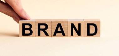 Ahşap arka planda tahta bloğa yazılmış bir marka..