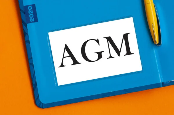 Agmという言葉は ノートのために白い紙に黒いマーカーで書かれています Agm 年次総会 — ストック写真