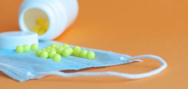 Hapları turuncu arka plandaki şişeden döktüm. Sağlık kavramı, virüslerden korunma, grip ve soğuk algınlıkları
