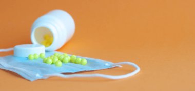 Hapları turuncu arka plandaki şişeden döktüm. Sağlık kavramı, virüslerden korunma, grip ve soğuk algınlıkları