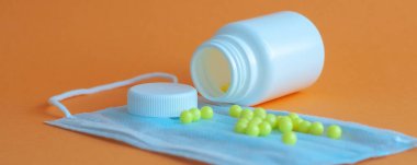 Hapları turuncu arka plandaki şişeden döktüm. Sağlık kavramı, virüslerden korunma, grip ve soğuk algınlıkları