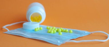 Hapları turuncu arka plandaki şişeden döktüm. Sağlık kavramı, virüslerden korunma, grip ve soğuk algınlıkları