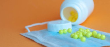 Hapları turuncu arka plandaki şişeden döktüm. Sağlık kavramı, virüslerden korunma, grip ve soğuk algınlıkları