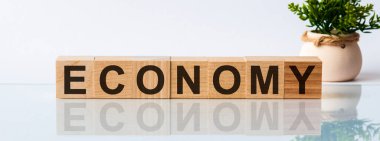 Tahta blokta ekonomi kelimesi yazıyor. Tahta masadaki karar metni üst görünüm konseptiniz için