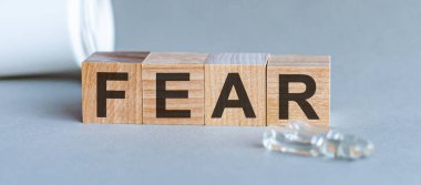 Tahta blokta yazan korku kelimesi. Ön manzara. Ölüm, konsept için gri arkaplan korku metni.