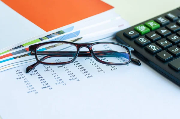 Sayılı bir belgede gözlük ve hesap makinesi resmi.