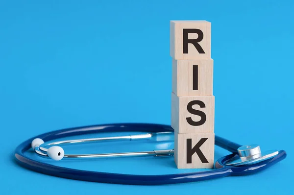 Risk Λέξη Γραμμένο Ξύλινα Μπλοκ Και Στηθοσκόπιο Γαλάζιο Φόντο Ασφάλιση — Φωτογραφία Αρχείου