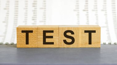 Tahta arka plandan yapılmış test kelimesi. İş konsepti. Test işareti, sınav, öğrenme konsepti. Tahta küplerle yazılmış kelime testi. Eğitim kalitesi kontrolü. Test arkaplanı