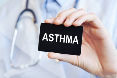 Doktor elinde ASTHMA yazılı siyah bir kart tutuyor, tıbbi konsept.