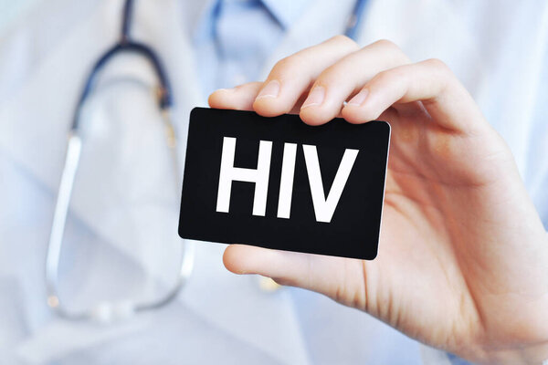 Doctor holding a black paper card with text HIV, medical concept